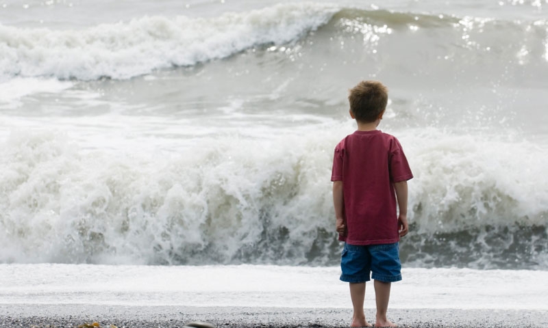 Kid watches the waves at Rialto Beach